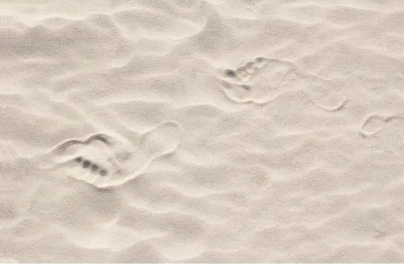Take your first step. Footprints in the sand.